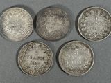 quatre pièces d'argent sur lesquelles figurent les noms de différents pays