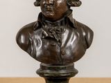 bronze bust of a man in a suit sitting on a table