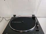 la platine est noire et est équipée d'un couvercle transparent