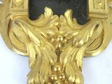 a gold clock with a black face on a white surface