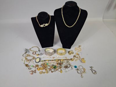 two black mannequins with necklaces and bracelets on display
