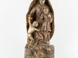 an old statue of a woman holding a child and a dog