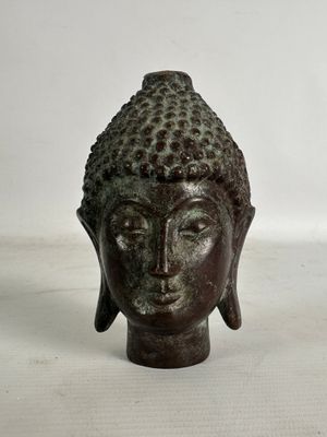 statue représentant une tête de Bouddha sur fond blanc