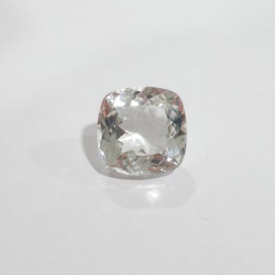an uncutted cushion cut diamond on a white surface