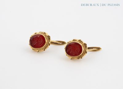 pair of gold and red glass cufflinks on a white background