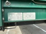 une photo d'un camion vert garé sur un parking