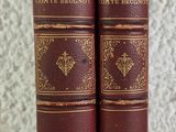 two old books sitting on top of each other on a table