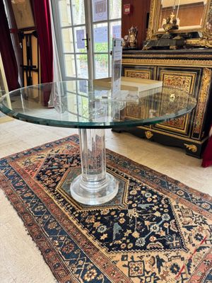 une photo d'une table en verre avec un tapis posé au sol
