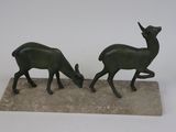 statue représentant un couple d'antilopes sur un socle en pierre