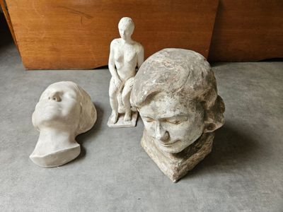 une statue représentant un homme assis à côté d'un buste de femme