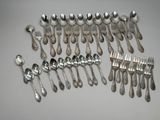 a lot of silver spoons and forks on the table
