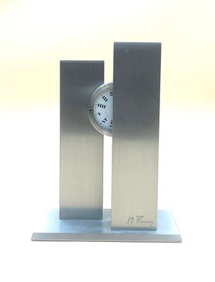 a silver clock that is on top of a metal stand