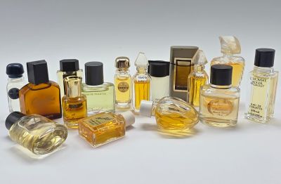 de nombreux flacons de parfum de toutes sortes posés sur une surface blanche