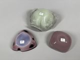 three different colored vases sitting on a white surface