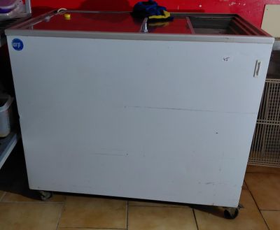 a small kitchen with a red wall and a white cabinet
