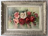tableau représentant des roses rouges et blanches dans un cadre argenté, accroché à un mur blanc