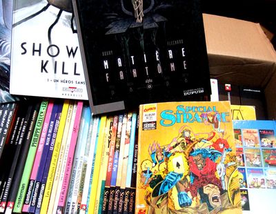 a box full of comics and books on a table