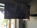 a flat screen tv hanging from the ceiling in the living room