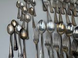 a lot of silver spoons and forks on the table