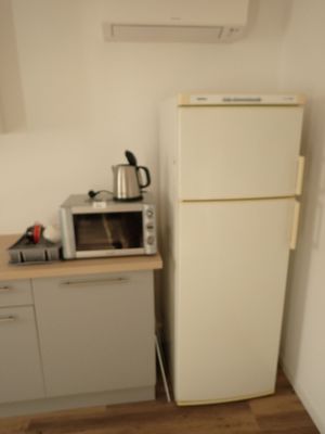 a small kitchen with a microwave and a refrigerator in it