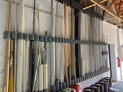 many baseball bats hanging on the wall in the garage