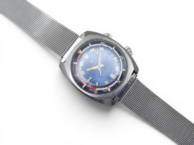 une image d'un gros plan d'une montre-bracelet sur une surface blanche