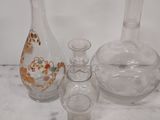 several glass vases sitting on a table with a white background