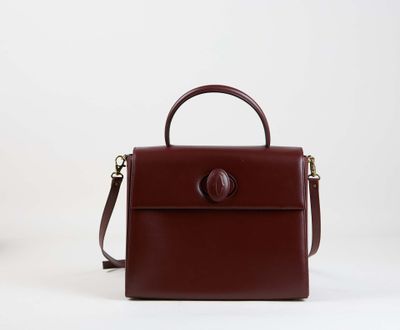 un sac à main marron posé sur une surface blanche