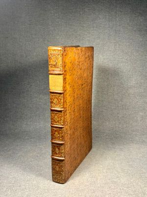 an old book sitting on top of a table next to a gray background