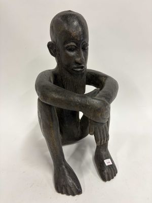 statue représentant un homme assis par terre, les mains posées sur les genoux