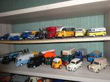 de nombreuses petites voitures et camions sur une étagère dans une pièce