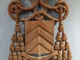 a wooden plaque with tassels hanging on the wall