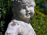a stone statue of a boy holding a bird in his hand