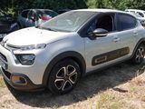 une voiture argentée garée dans un champ avec d'autres voitures