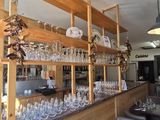a bar with wine glasses on the shelves above it
