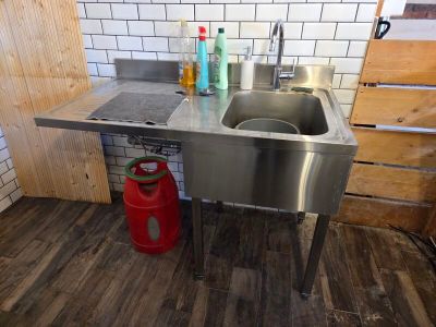 a stainless steel sink and a red can in the kitchen