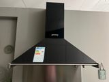 une plaque de cuisson noire sur laquelle est posé un smartphone