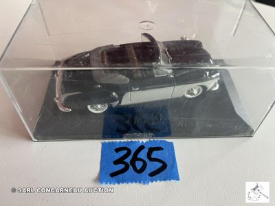 une petite voiture dans une boîte transparente sur laquelle est apposée une étiquette de prix