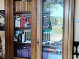 a wooden cabinet with a glass door in a room