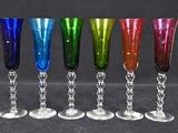 six different colored wine glasses are lined up in a row