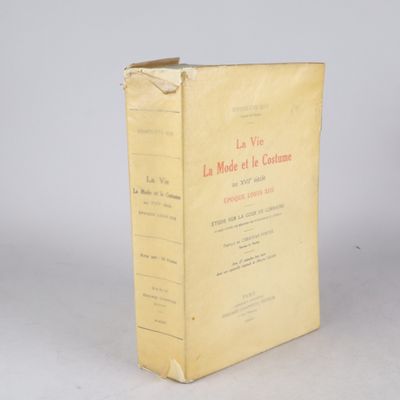 un vieux livre posé sur une table à côté d'un mur blanc