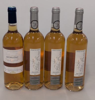 quatre bouteilles de vin sont alignées sur une surface blanche