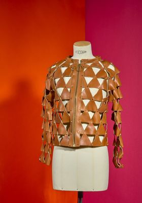 leather jacket on a mannequin stand against a red and orange wall