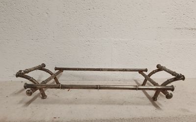 a metal bench that is sitting on a cement floor
