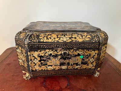 une boîte noire et dorée posée sur une table en bois