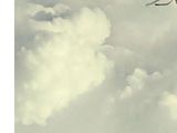 someone is flying a kite high in the sky on a cloudy day