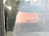 a reflection of a man in the window of a bus