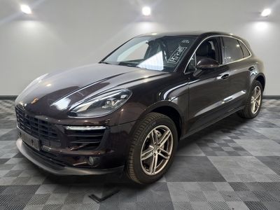 La Porsche Macan est garée dans le garage, sur un sol à motif damier.