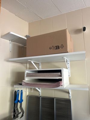 a shelf that has a box on it and a pair of scissors on it