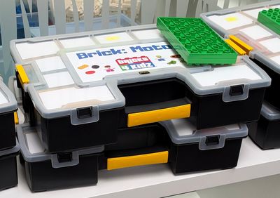 many boxes of legos sitting on a shelf in a room